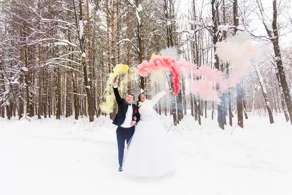 Наречений і наречений з димовими бомбами взимку — стокове фото