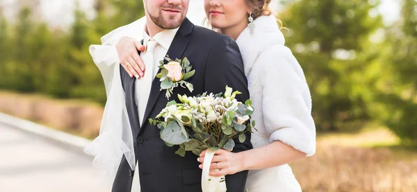 Bruden och brudgummen embracing på deras bröllop dag närbild — Stockfoto