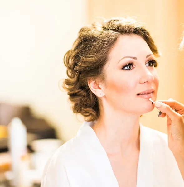 Elegante novia hermosa conseguir maquillaje en el salón de belleza — Foto de Stock