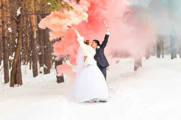 Brautpaar mit Rauchbomben im Winter — Stockfoto