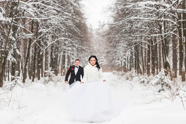 Mariée et marié court sur un parc d'hiver — Photo