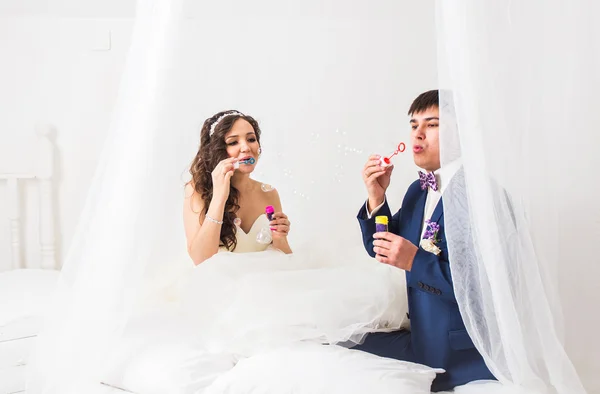 Boda pareja soplando burbujas — Foto de Stock