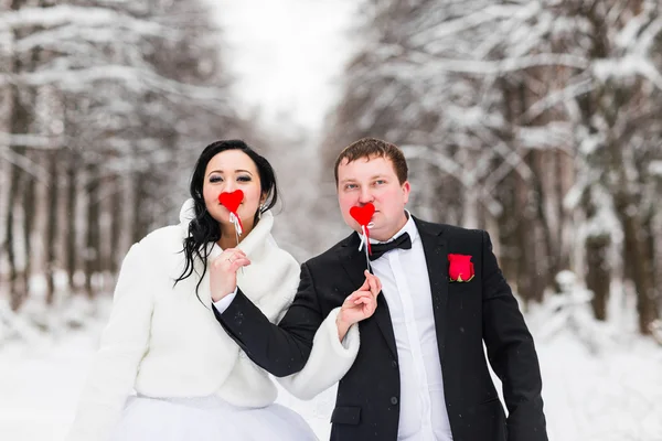 Matrimonio coppia in posa con bastone cuori, maschera — Foto Stock