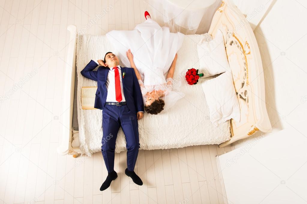 Bride and a groom lying on the bed