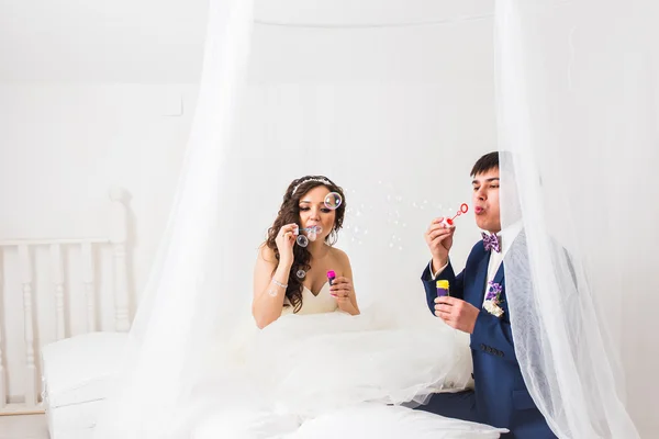 Wedding couple blowing bubbles — Stock Photo, Image