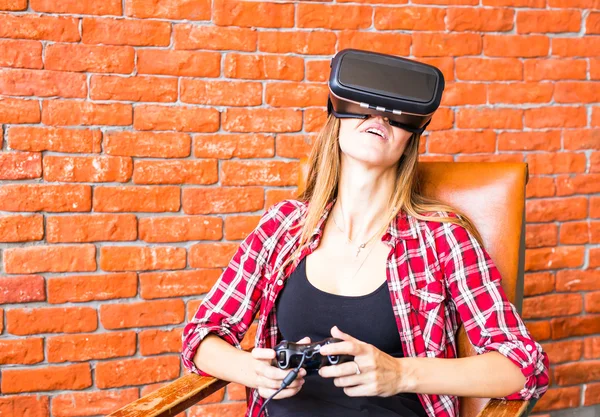 Жінка грає у відеоігри з джойстиком і VR-пристроєм — стокове фото