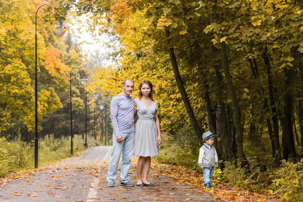 Familia amigable caminando en el parque en otoño juntos — Foto de Stock