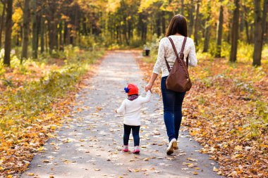 Anne ve bebeği. Anne ve kızı sonbahar parkında.