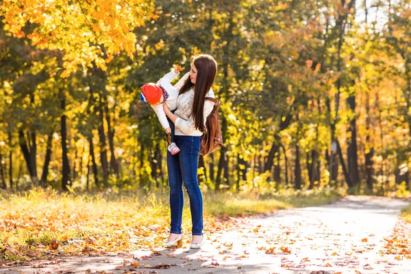 Молодая мать играет со своей дочерью в осеннем парке — стоковое фото