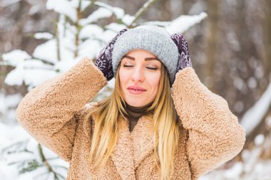 Kışın karlı manzarada genç bir kadının güzel kış portresi.