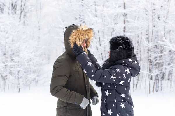 Jovem casal apaixonado se divertir na floresta nevada. Férias activas de Inverno. — Fotografia de Stock