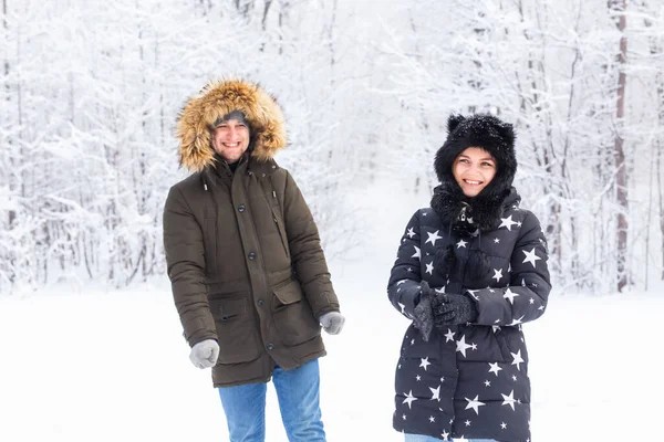 Divertimento, estação e conceito de lazer - casal amor joga madeira de inverno na neve. — Fotografia de Stock