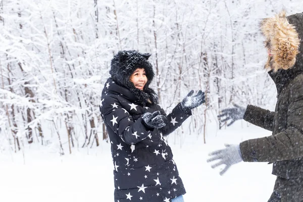 คู่รักที่มีความสุขโยนหิมะขึ้นในป่าฤดูหนาว — ภาพถ่ายสต็อก