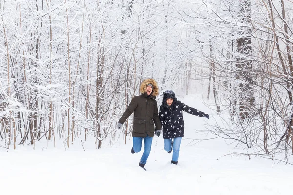 겨울에 눈덮인 숲 속을 거닐고 있는 행복 한 부부 — 스톡 사진