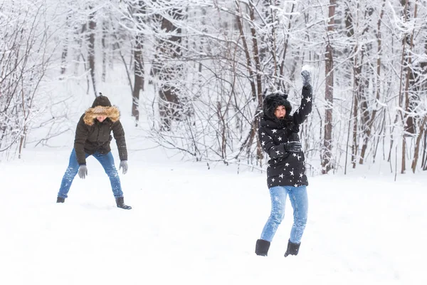 Fun, concept de saison et de loisirs - couple amoureux joue du bois d'hiver sur la neige — Photo