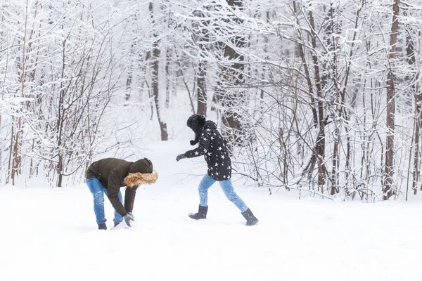 Divertimento, estação e conceito de lazer - casal amor joga madeira de inverno na neve — Fotografia de Stock