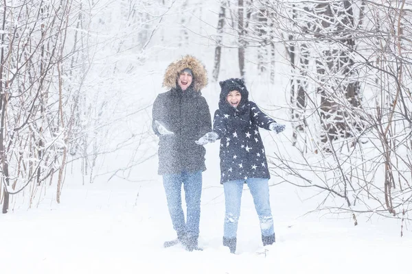 Jovem casal brincando com neve no parque de inverno — Fotografia de Stock