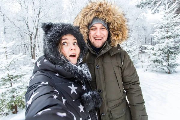 Sezon i koncepcja związku - śmieszne para biorąc selfie w okresie zimowym — Zdjęcie stockowe