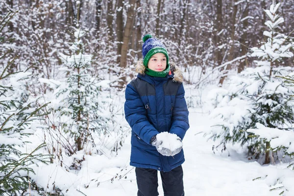 Счастливый мальчик бросает снег. Детская, сезонная и зимняя концепция. — стоковое фото