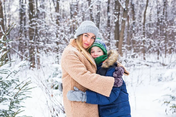 Portrait de mère heureuse avec enfant fils en hiver à l'extérieur. Parc enneigé. Famille monoparentale. — Photo