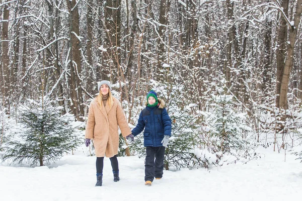 Портрет щасливої матері з сином взимку на відкритому повітрі. Сніжний парк. Одноосібний батько . — стокове фото