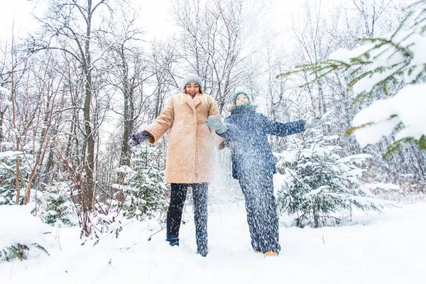 Parenting, fun et concept de saison - Bonne mère et son fils s'amusent et jouent avec la neige dans la forêt d'hiver — Photo