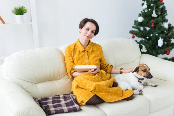 クリスマス、休日、人々のコンセプト-幸せな若い女性は自宅で本を読んで. — ストック写真