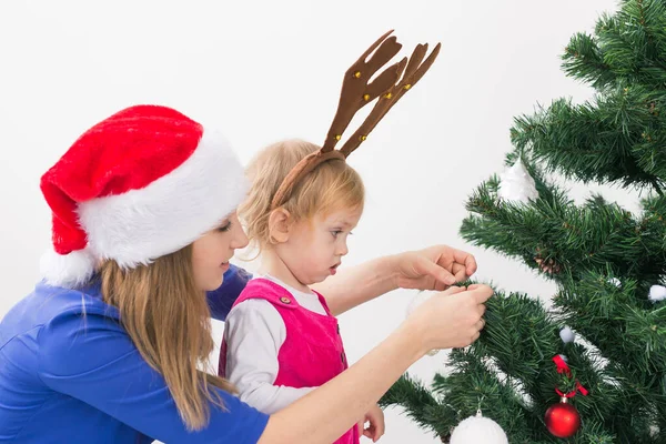 妈妈和女儿装饰圣诞树，玩得很开心。假日和庆祝概念. — 图库照片