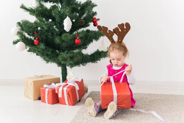 Kind hält Weihnachtsgeschenk in der Hand. Kind hat Spaß zu Hause. Winterferienkonzept — Stockfoto