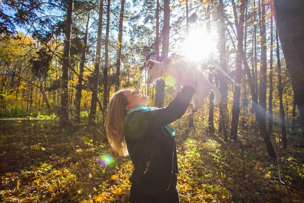 Vrouw met haar hond in het herfstpark. Meisje dat buiten met Jack Russell Terrier speelt. Huisdier en volk concept. — Stockfoto