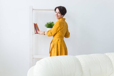 Gülümseyen güzel esmer, oturma odasında dinleniyor.