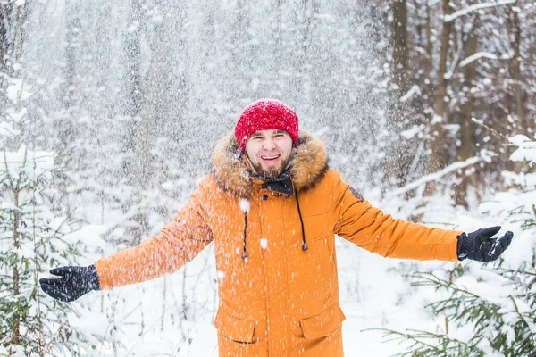 Jeune homme jetant de la neige dans la forêt d'hiver. Le gars s'amuse dehors. Activités hivernales. — Photo