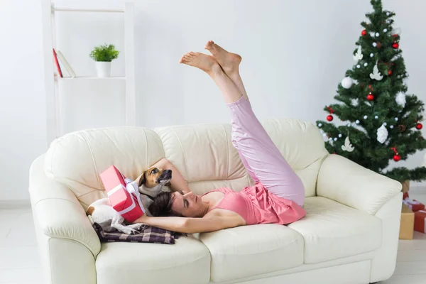 クリスマスツリーとリビングルームで素敵な犬と幸せな若い女性。休日のコンセプト. — ストック写真