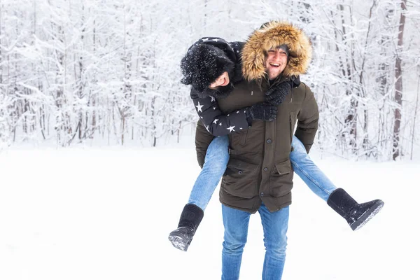Retrato de jovem casal feliz no parque de inverno com seu amigo por trás — Fotografia de Stock