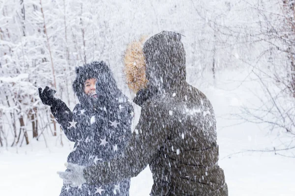 Divertimento, estação e conceito de lazer - casal amor joga madeira de inverno na neve. — Fotografia de Stock