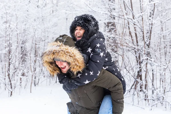 Portret szczęśliwej młodej pary w parku zimowym z przyjacielem za plecami — Zdjęcie stockowe