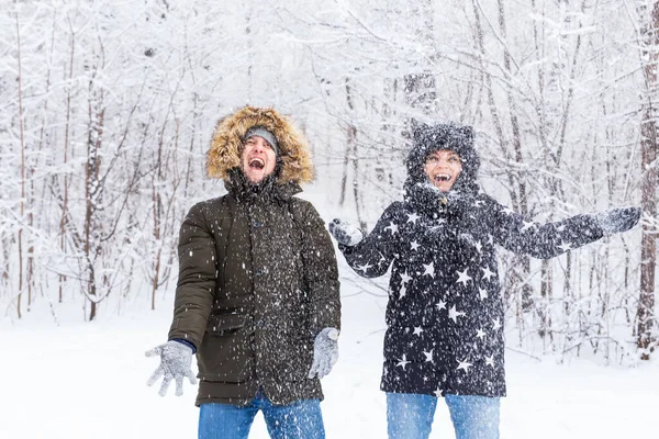 Heureux jeune couple vomir une neige dans une forêt d'hiver — Photo