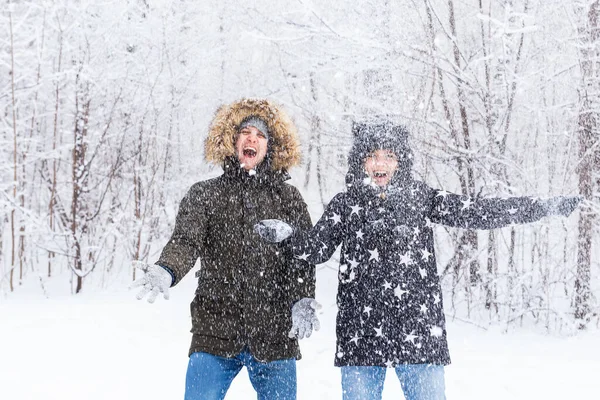 Heureux jeune couple vomir une neige dans une forêt d'hiver — Photo