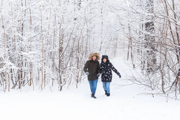Щаслива пара, що йде через засніжений ліс взимку — стокове фото