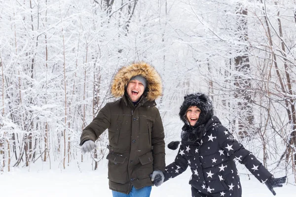Joyeux couple marchant dans une forêt enneigée en hiver — Photo