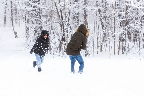 Estilo de vida, temporada e conceito de lazer - Engraçado casal jogando bola de neve no parque de inverno — Fotografia de Stock