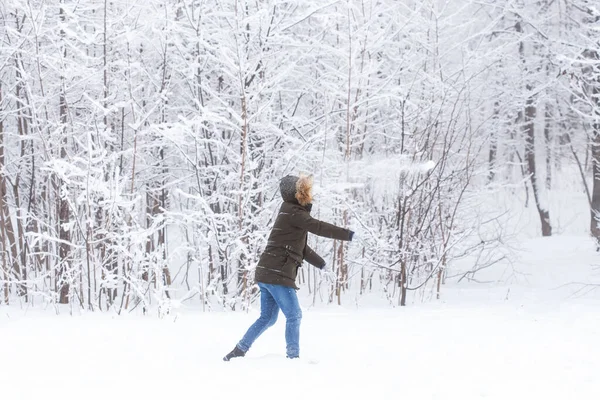 Estilo de vida, temporada e conceito de lazer - Engraçado casal jogando bola de neve no parque de inverno — Fotografia de Stock