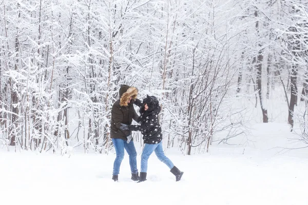 Mode de vie, saison et concept de loisirs - Couple drôle jouant boule de neige dans le parc d'hiver — Photo