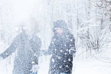 Genç çift kış parkında karla oynuyor.
