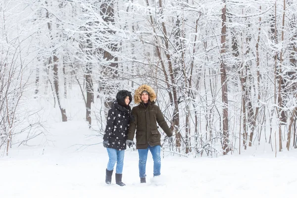 Счастливая влюбленная пара весело проводит время на свежем воздухе в снежном парке. Зимние каникулы — стоковое фото