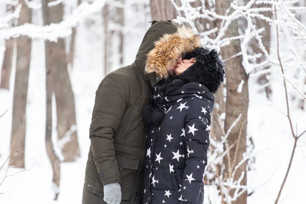 Młoda para miłości całuje się w zaśnieżonym parku. Sezon zimowy. — Zdjęcie stockowe