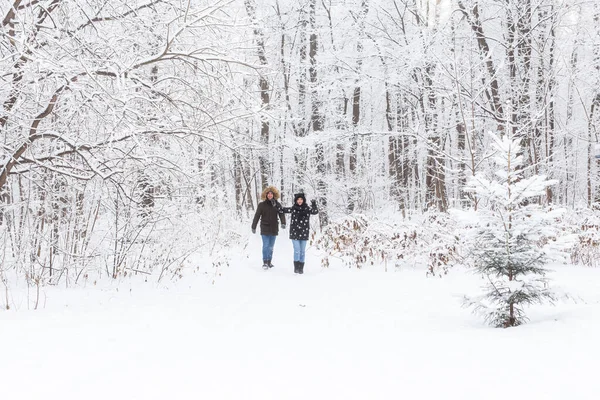 Joyeux couple marchant dans une forêt enneigée en hiver — Photo