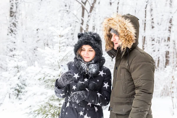 Tecnologias e conceito de relacionamento - Feliz casal sorrindo tirar uma selfie em uma floresta de inverno fora — Fotografia de Stock