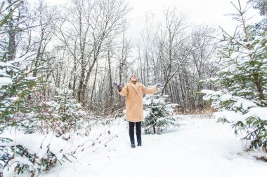 Güneşli kış gününde havaya kar atan genç bir kadın, o mutlu ve eğlenceli..