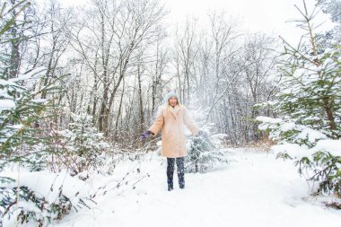Güneşli kış gününde havaya kar atan genç bir kadın, o mutlu ve eğlenceli..
